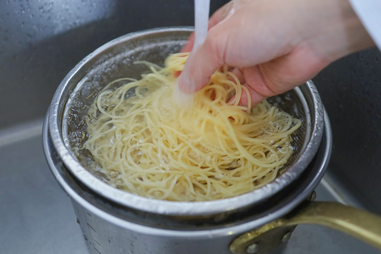 パスタを流水で締めている画像