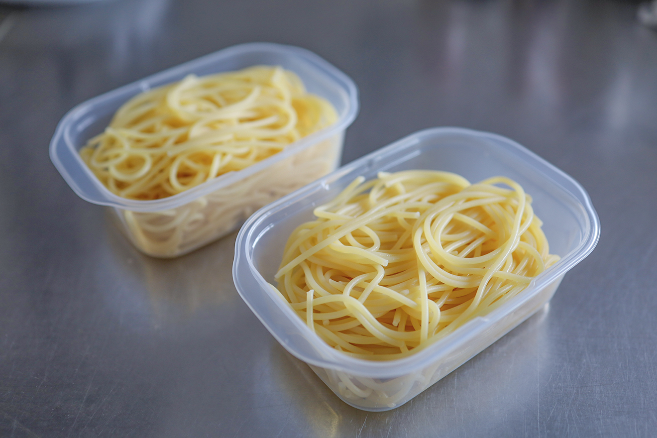 パスタを保存容器に入れている画像