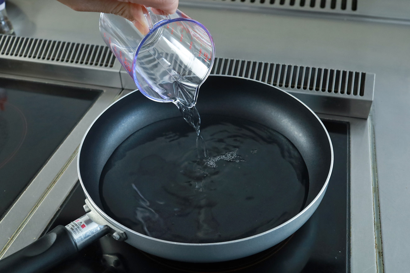 フライパンに水を入れている画像