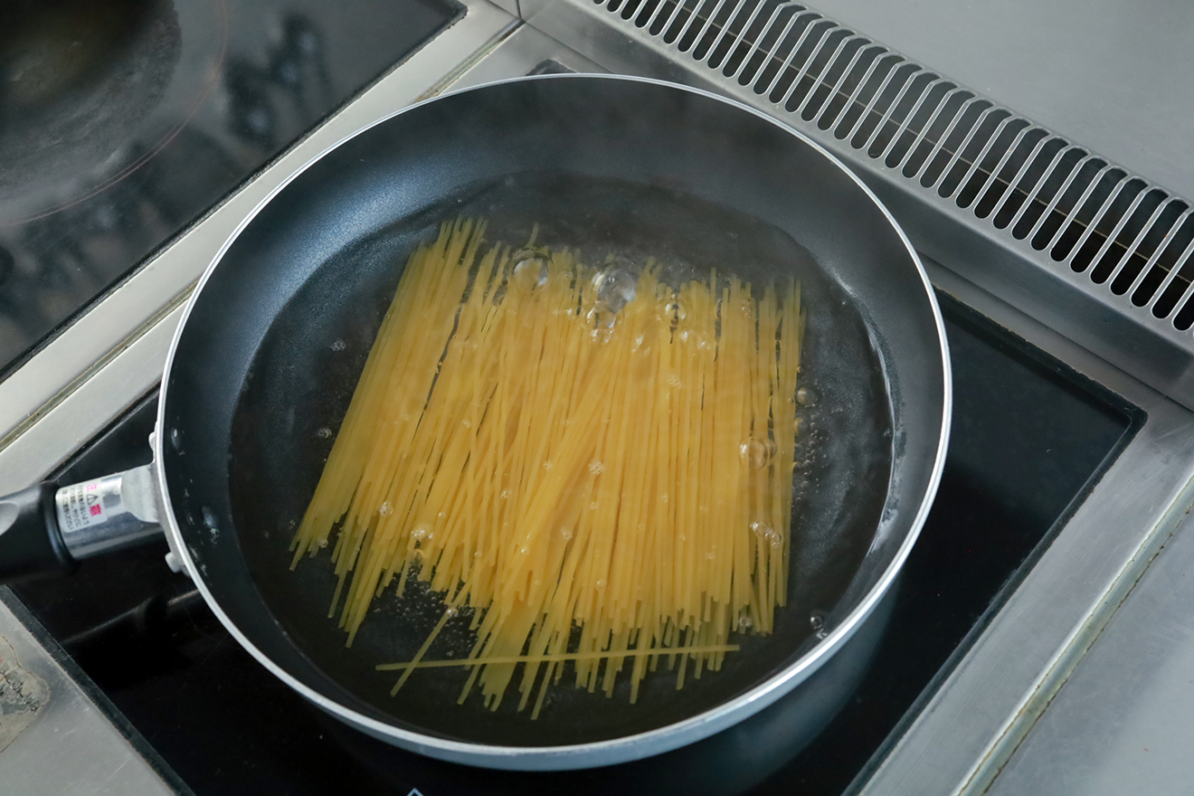 フライパンに入れたパスタの画像